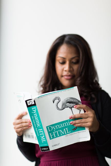 There is no relevant gardening or outdoor scene in the provided image. The image features a woman with dark hair reading a book titled 'Dynamic HTML' by O'Reilly, holding the book with both hands and 